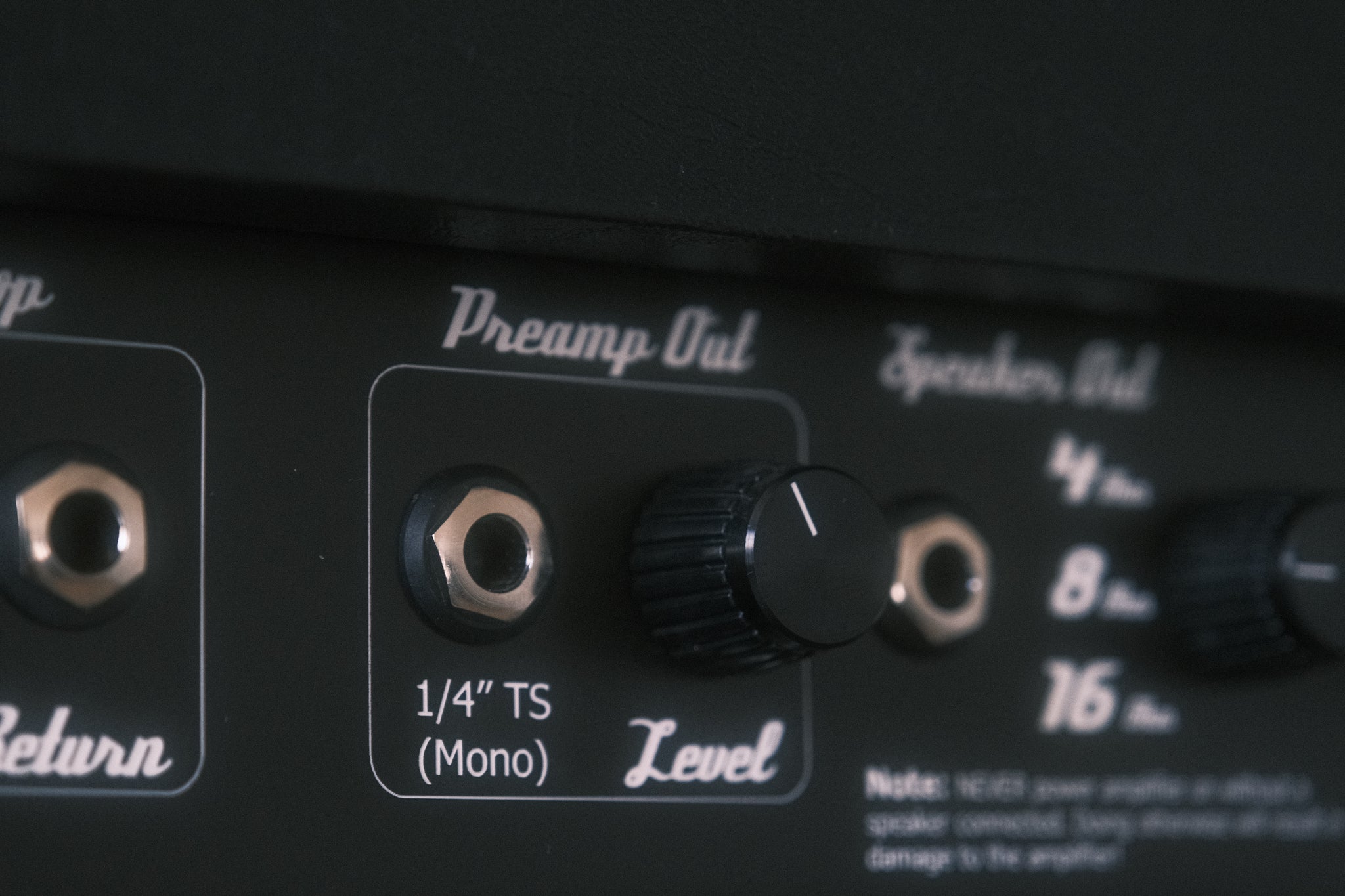 Close-up of an audio equipment panel with labeled connectors and knobs.